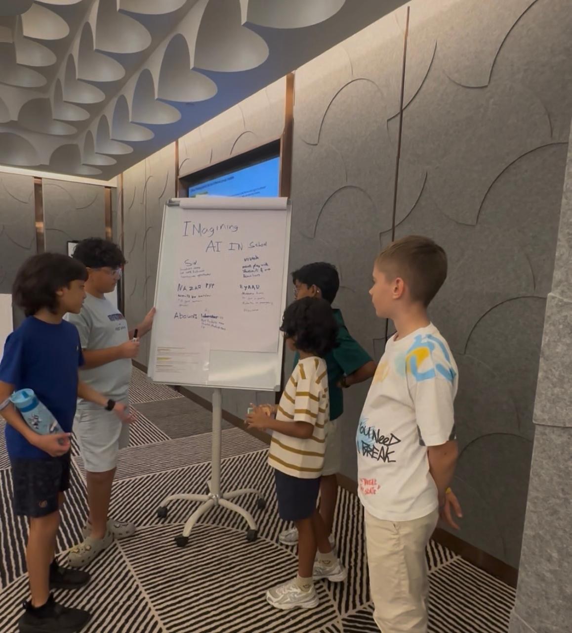 Group of children presenting team ideas on a flipchart — kids workshop Dubai