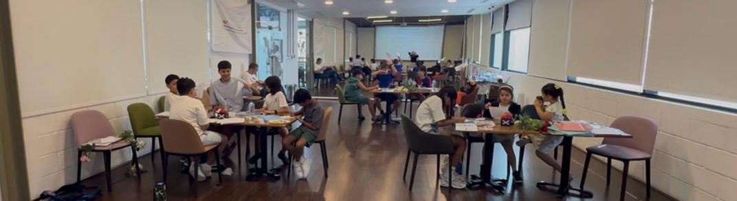 Full room of children at round tables — Transformation Avenue kids workshop Dubai